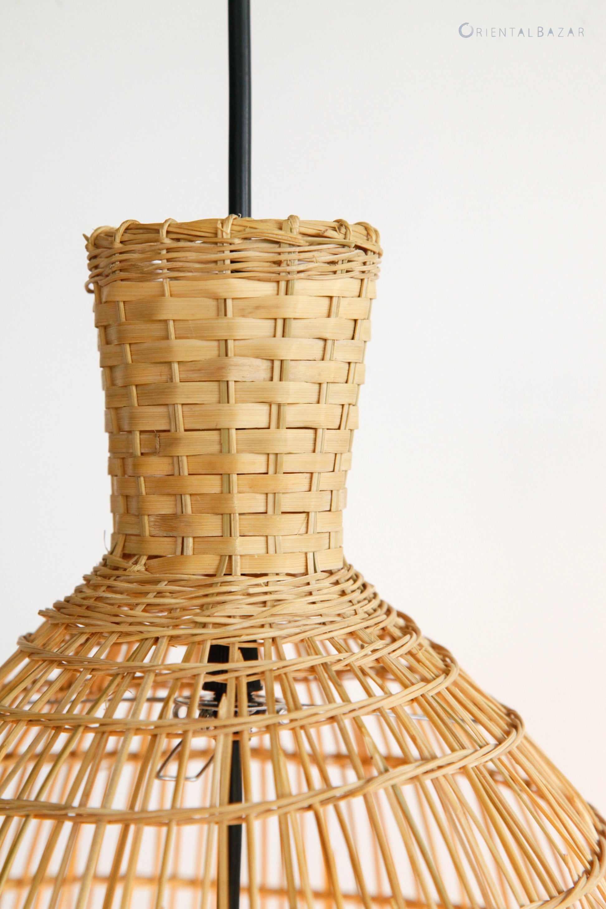 Closeup of the top of a woven bamboo lampshade on a white background