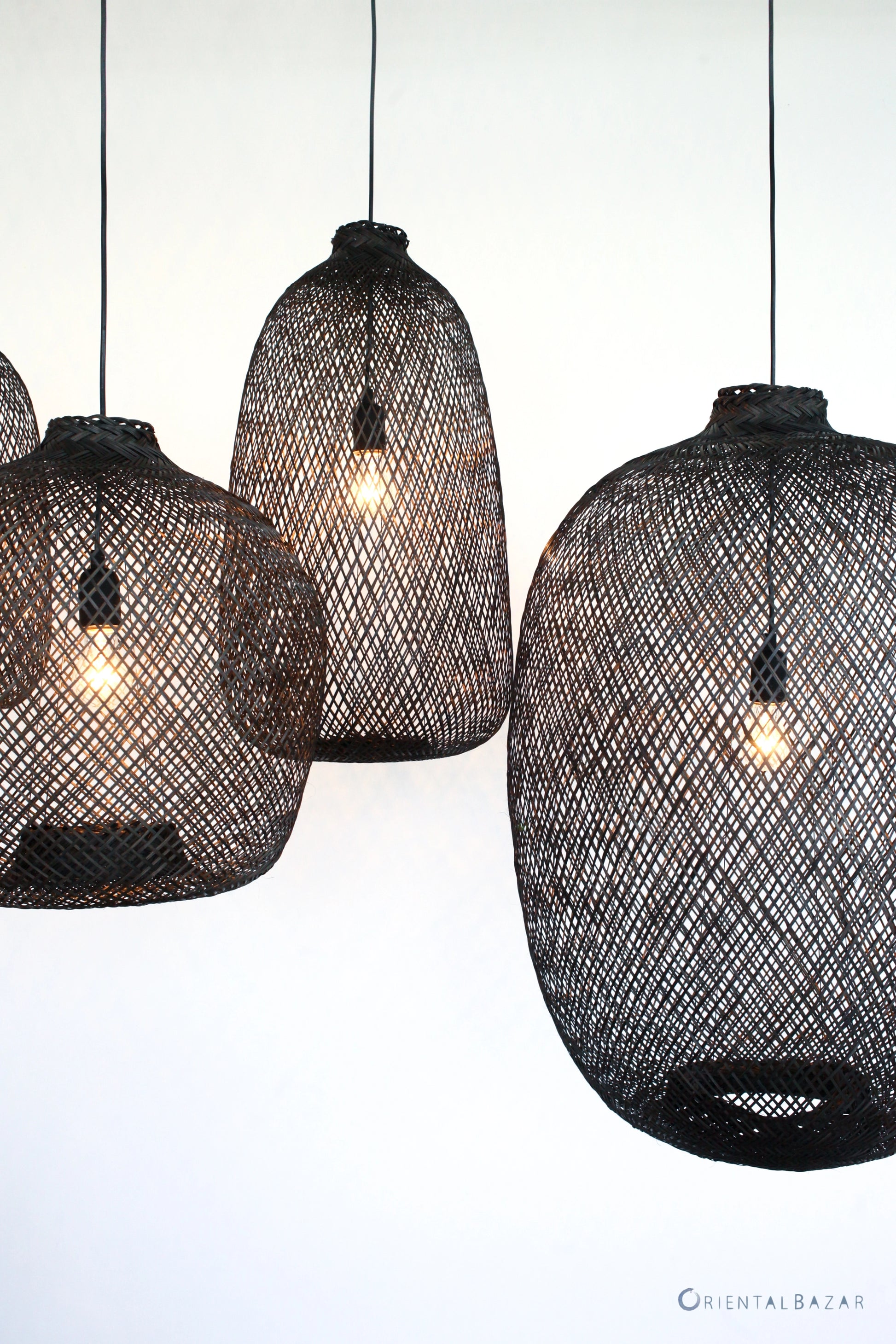 Black woven bamboo pendant lights on a white background