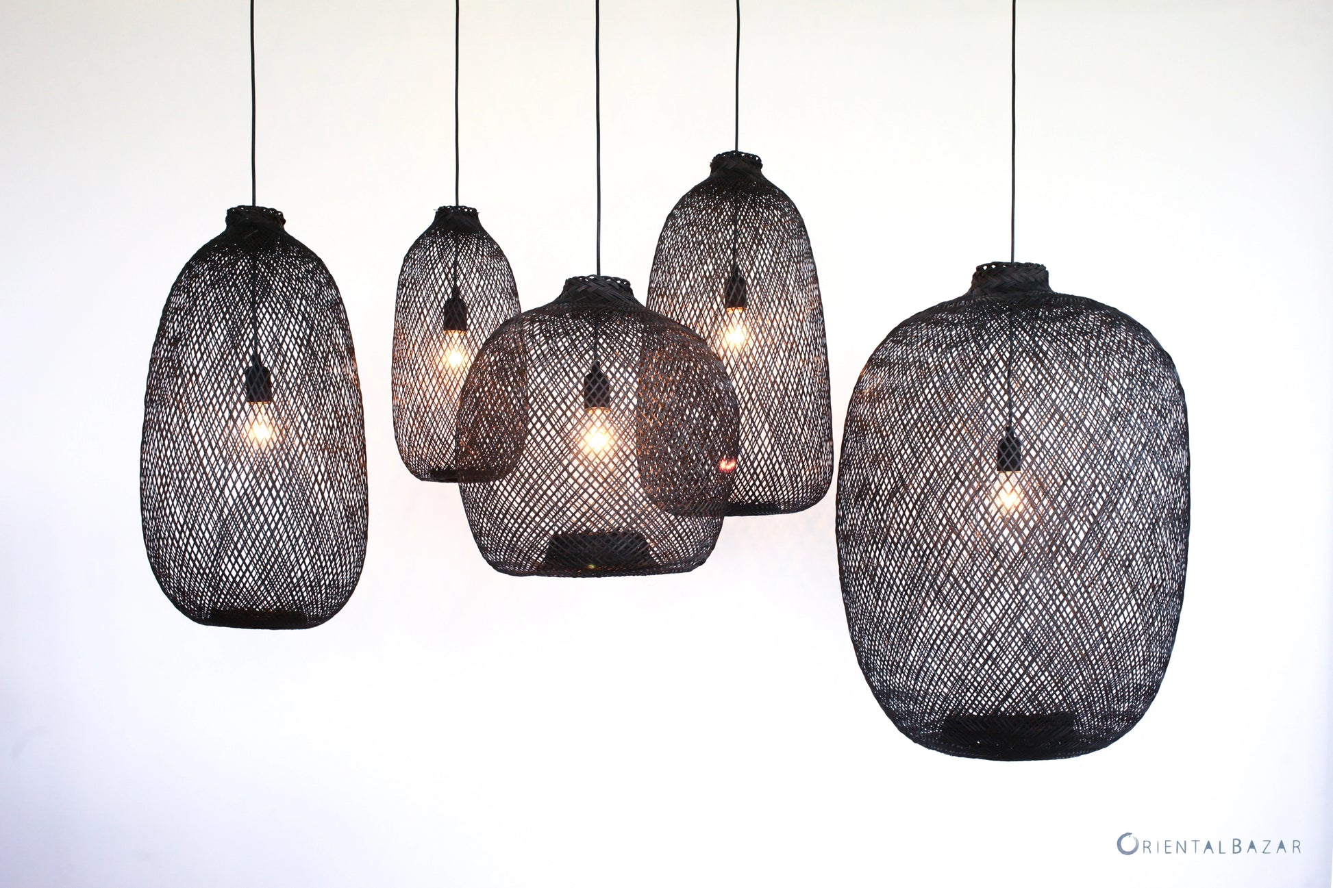 Set of black woven bamboo pendant lights on a white background