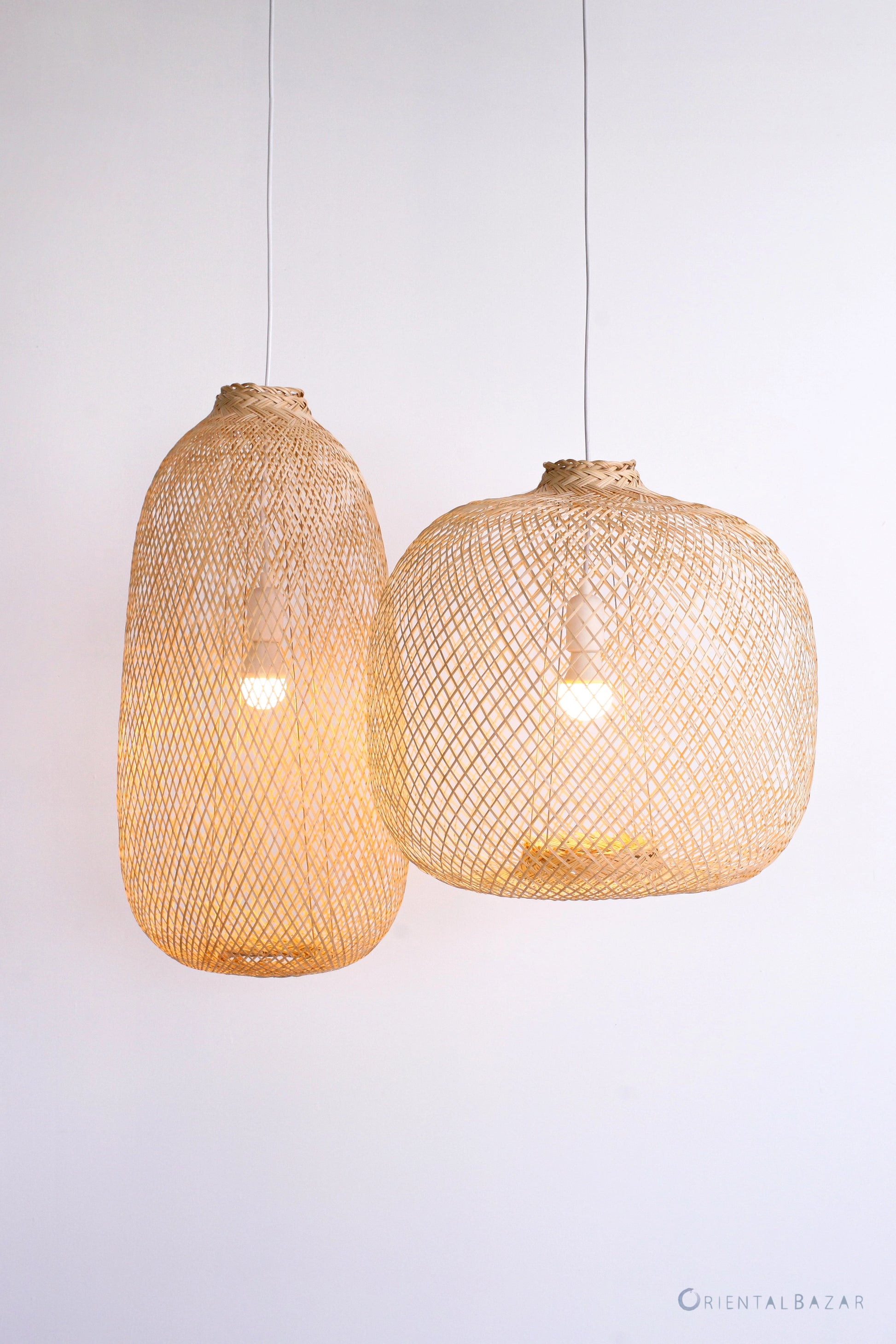 Two woven pendant lights hanging against a white background
