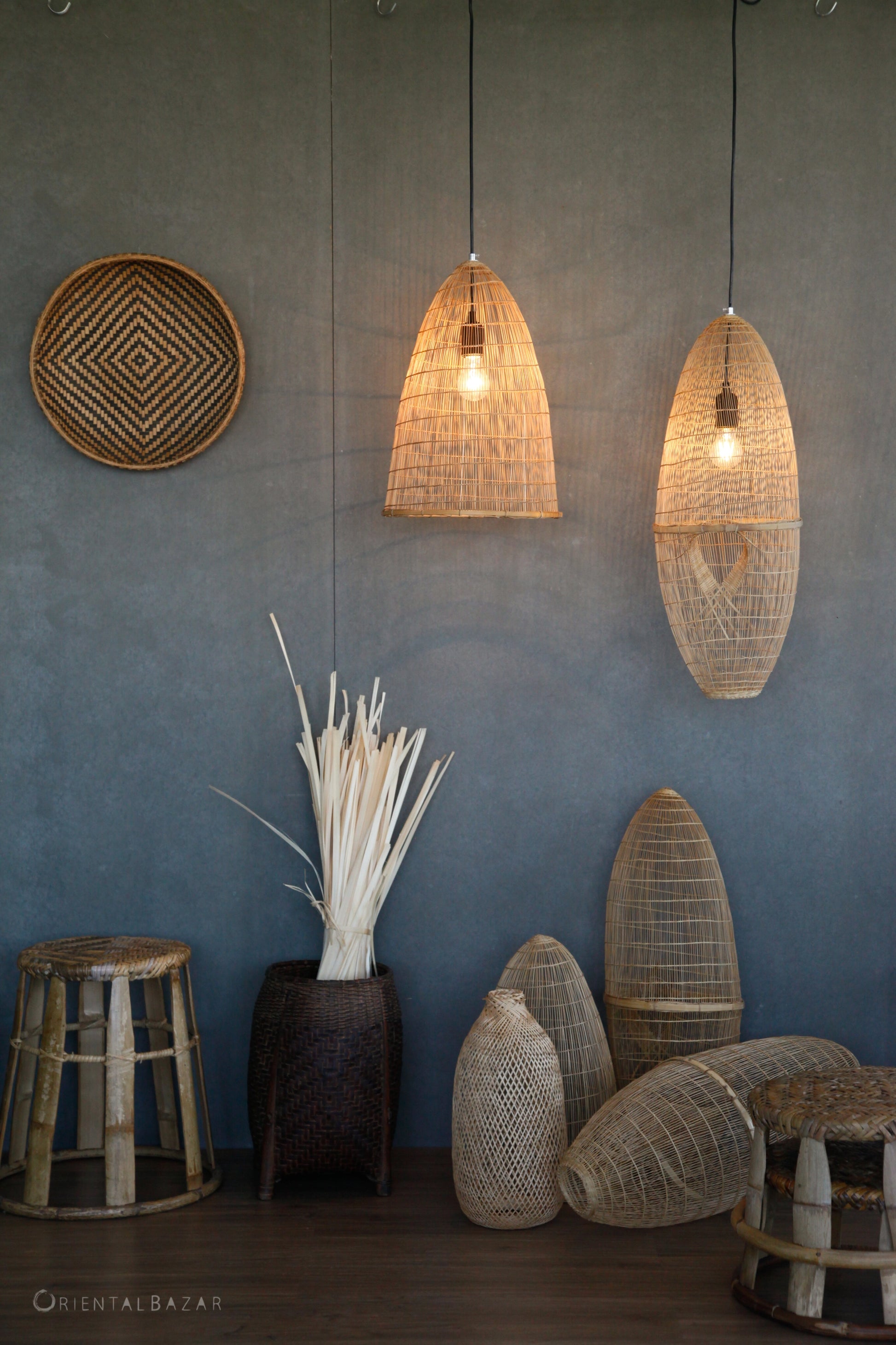 Woven bamboo pendant lights and decorative bamboo and rattan items against a gray wall.