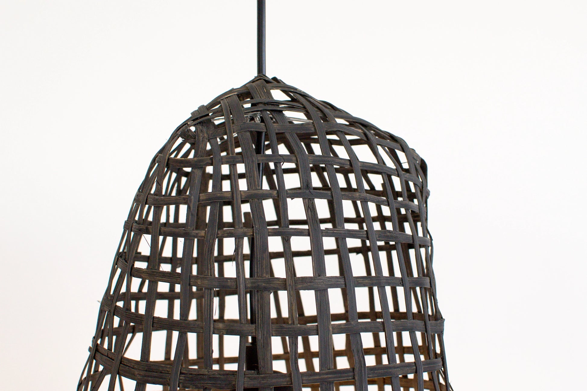 Woven dark charcoal bamboo pendant light on a white background