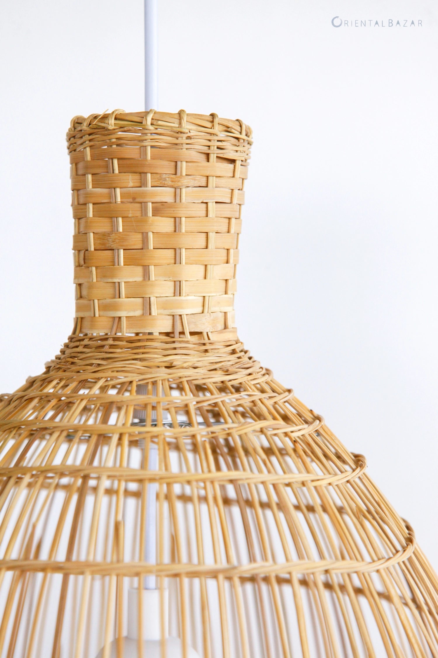 Close-up of woven bamboo pendant light against a white background