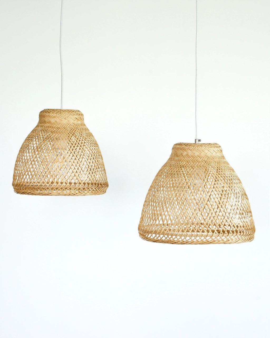 Two minimalist woven bamboo pendant lights on a white background