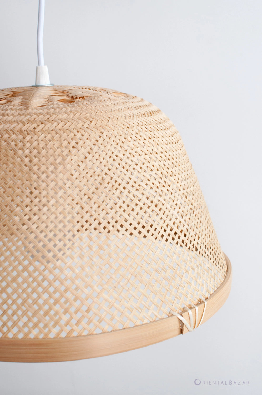 Woven bamboo pendant light with a neutral background