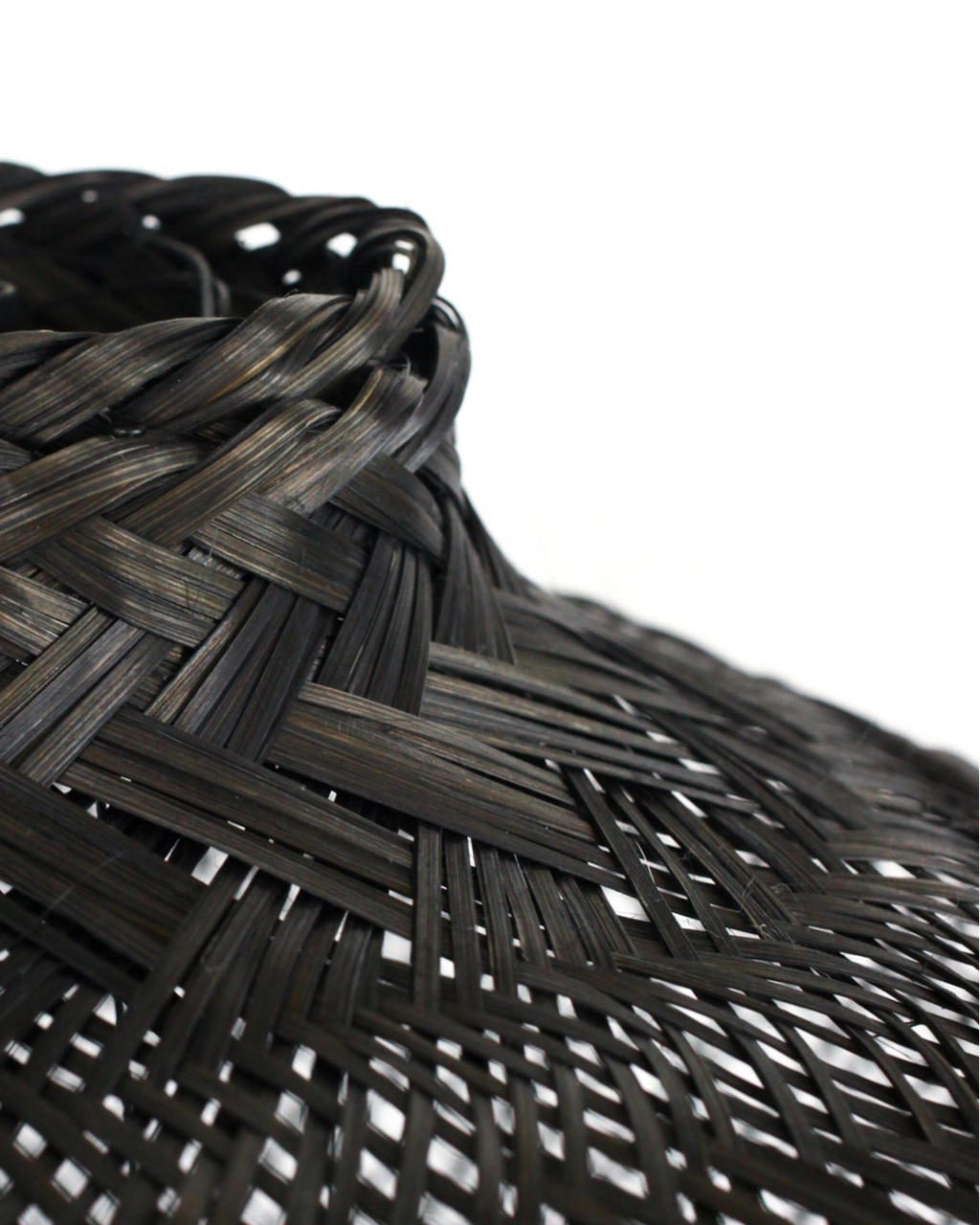 Closeup of a black woven bamboo light on a white background