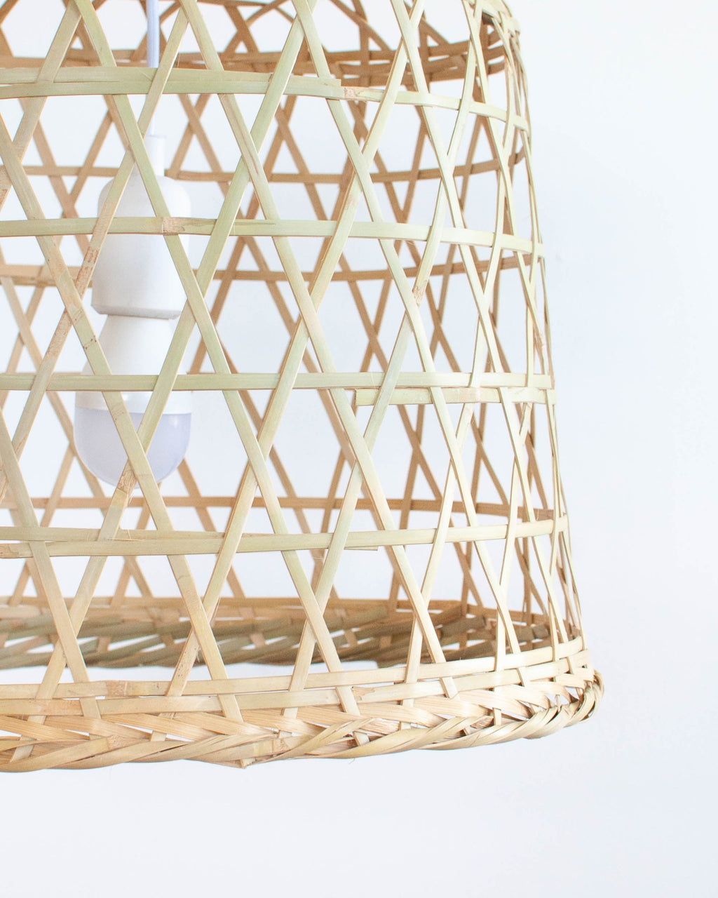 Woven bamboo pendant light against a white background