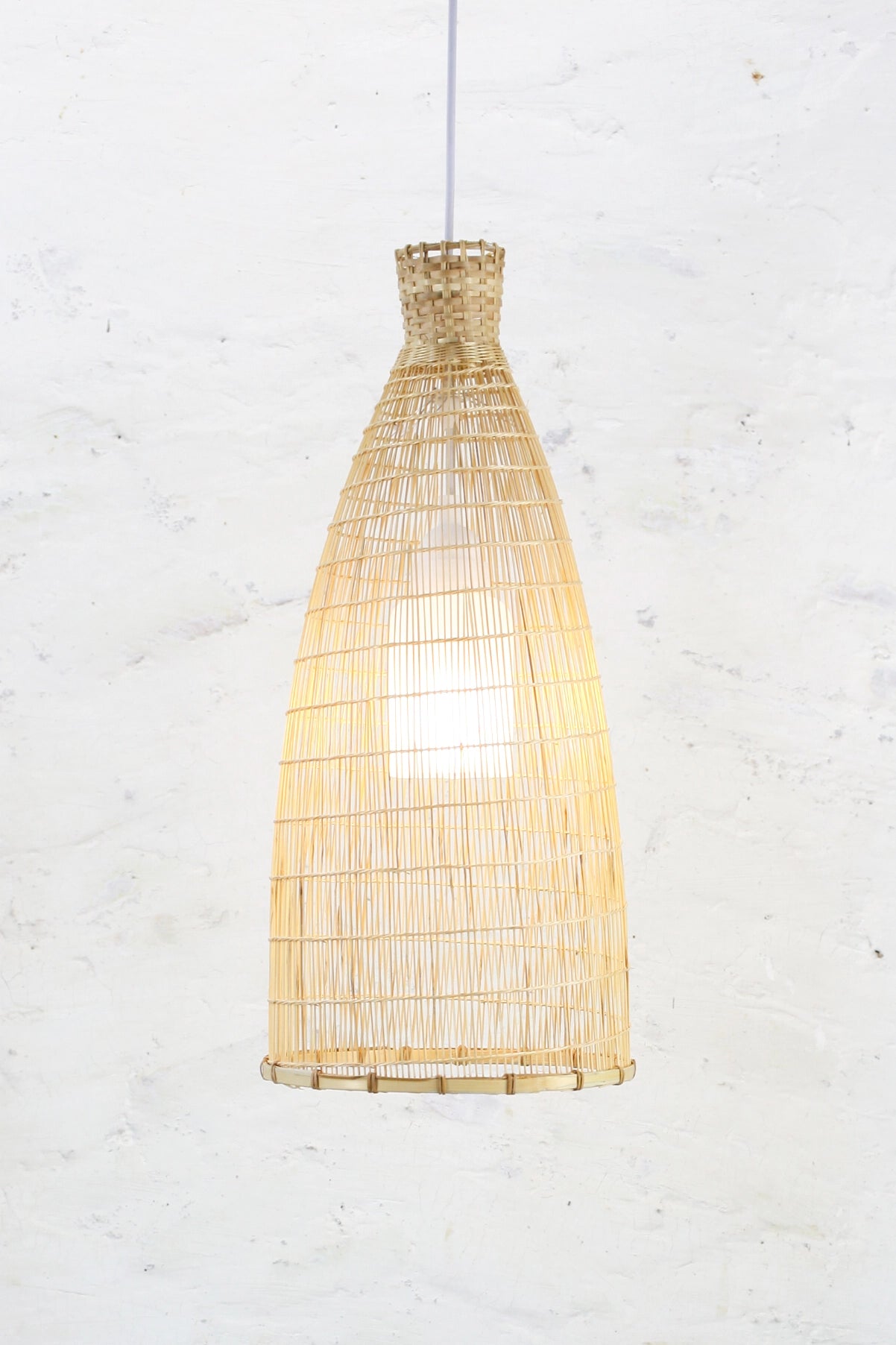 Boho Bamboo and rattan pendant light against a white textured wall