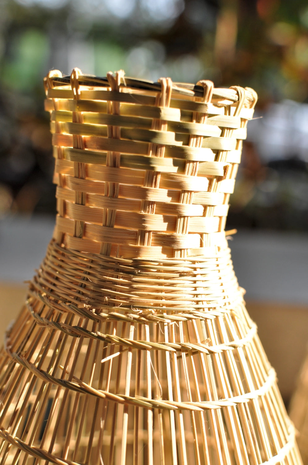 Close-up of a woven bamboo lamp under the sun