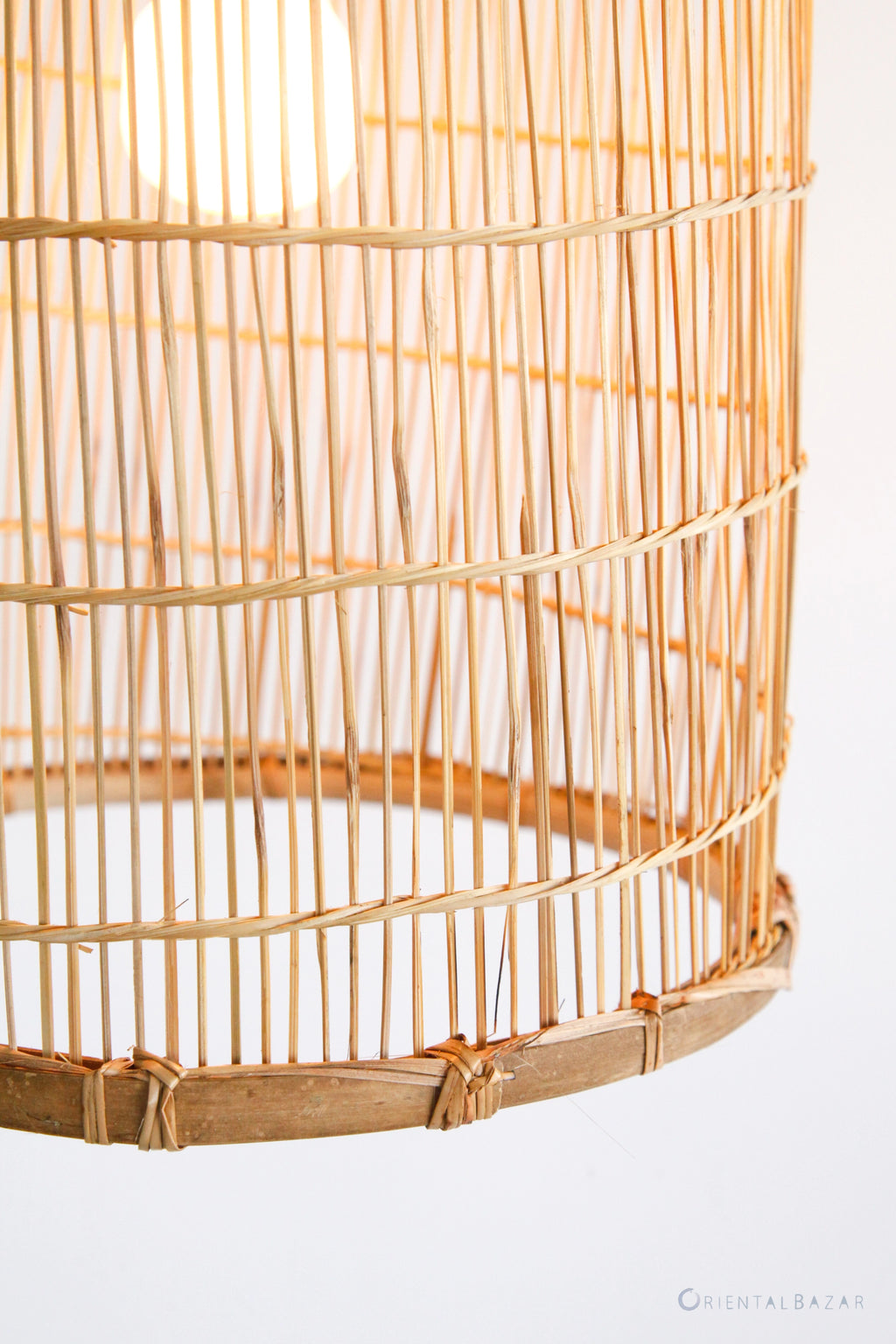 Close-up of the rim of a woven bamboo lampshade with rattan ties on a white background