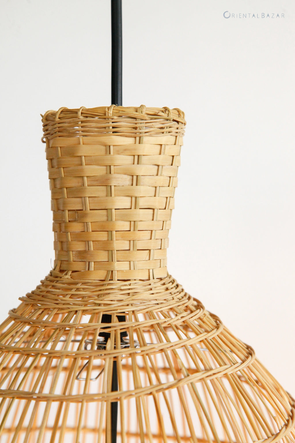 Closeup of the top of a woven bamboo lampshade on a white background