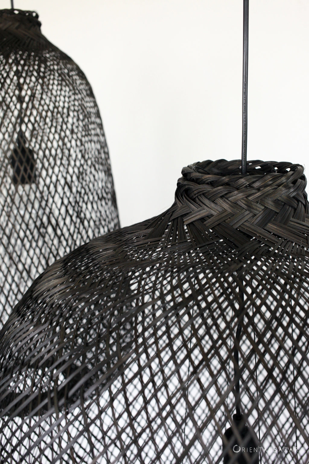 Black woven bamboo pendant lights against a white background