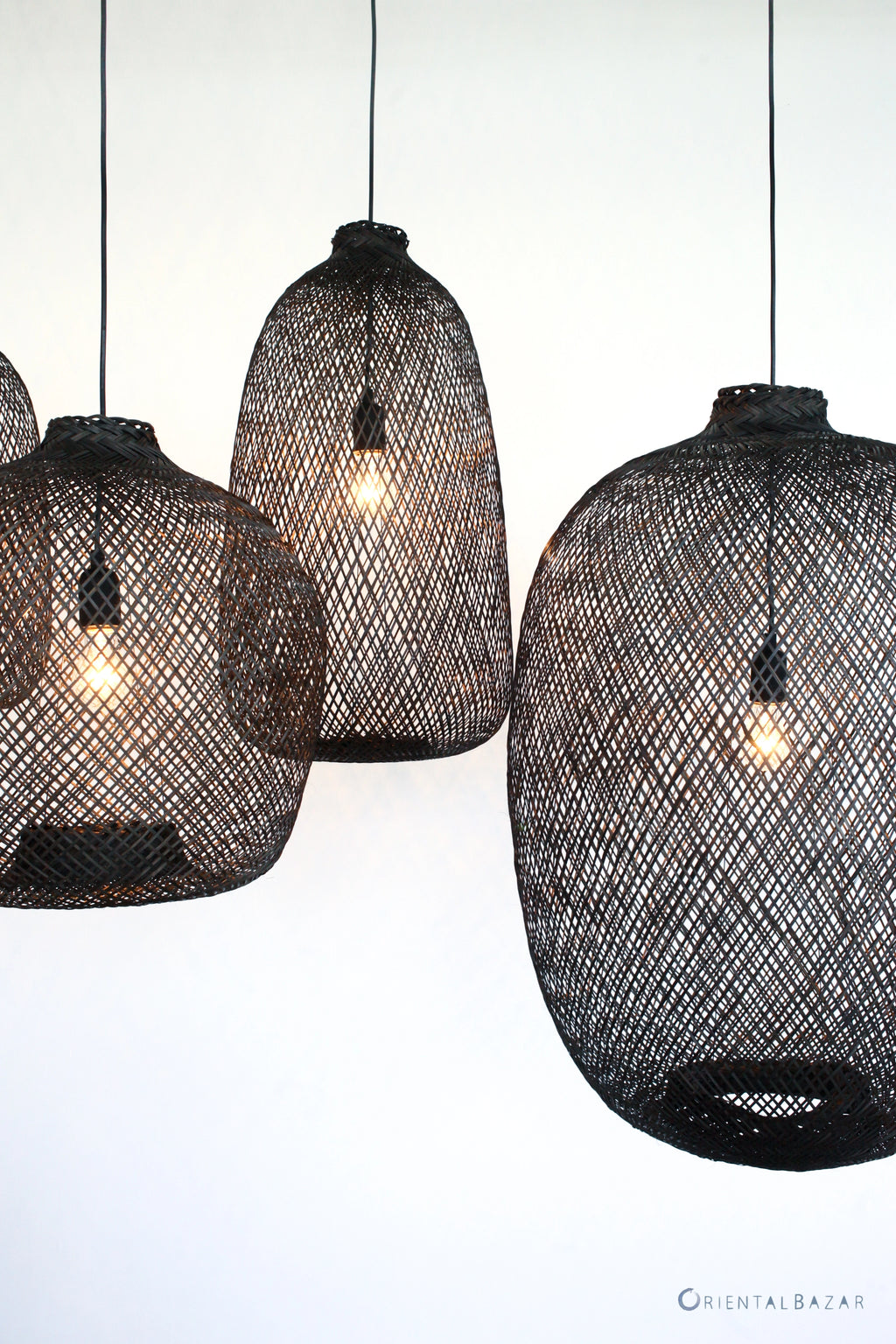 Black woven bamboo pendant lights on a white background
