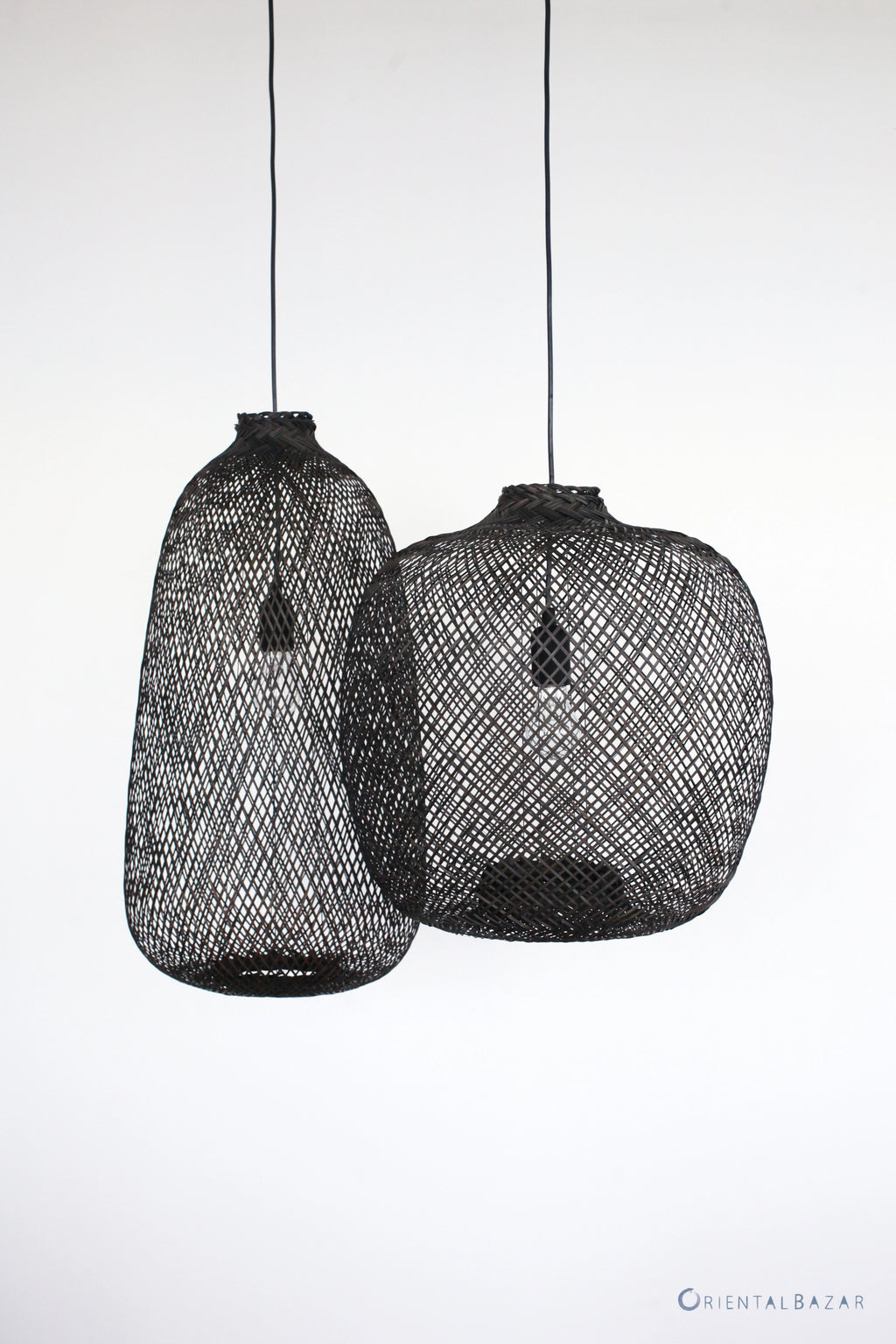 Two black woven bamboo pendant lights on a white background