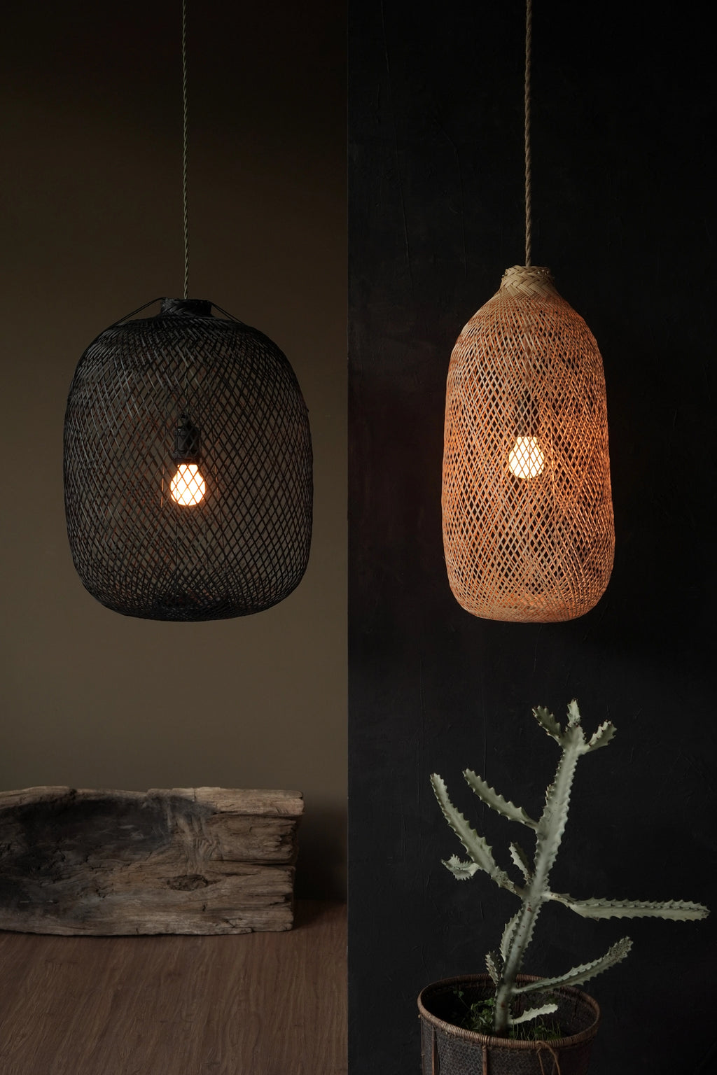 Two woven pendant lights with a plant and antique wood log on a dark background