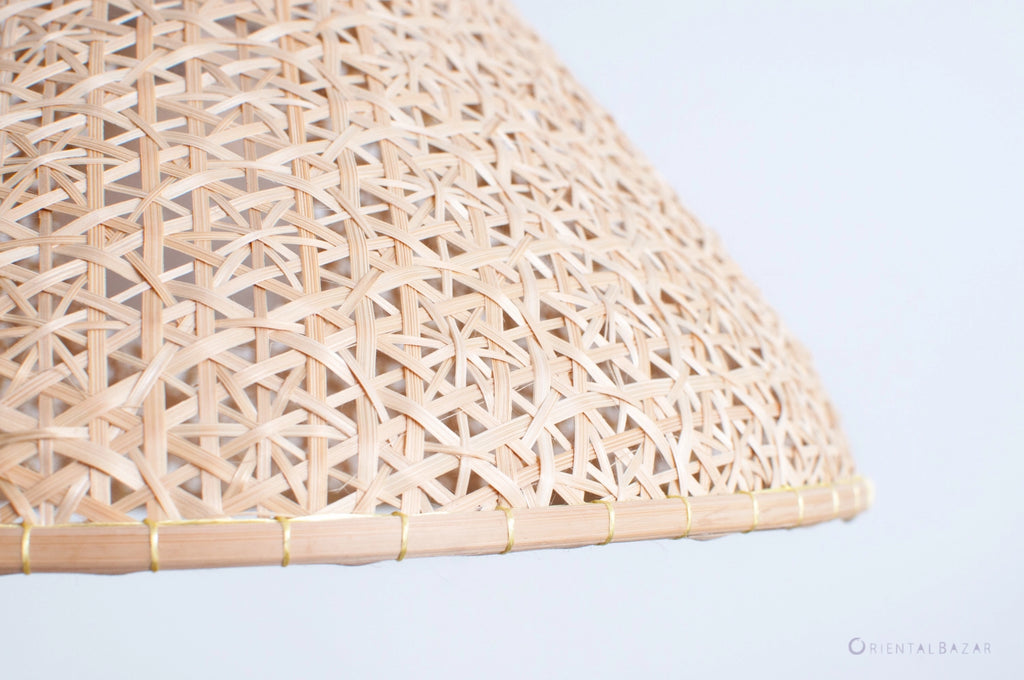 Close-up of a woven bamboo lampshade on a light gray background