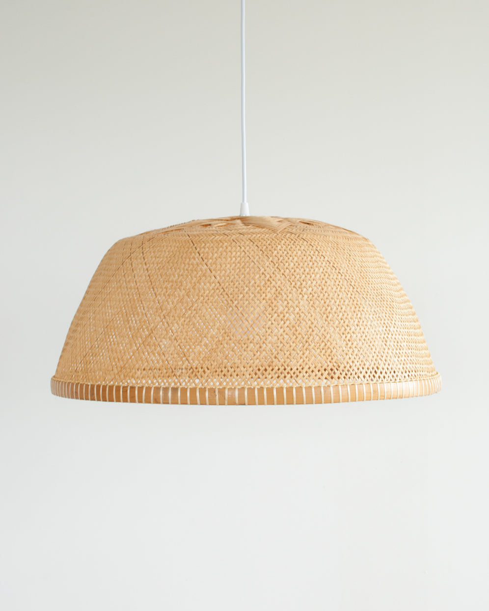 Woven rattan bamboo pendant light on a white background