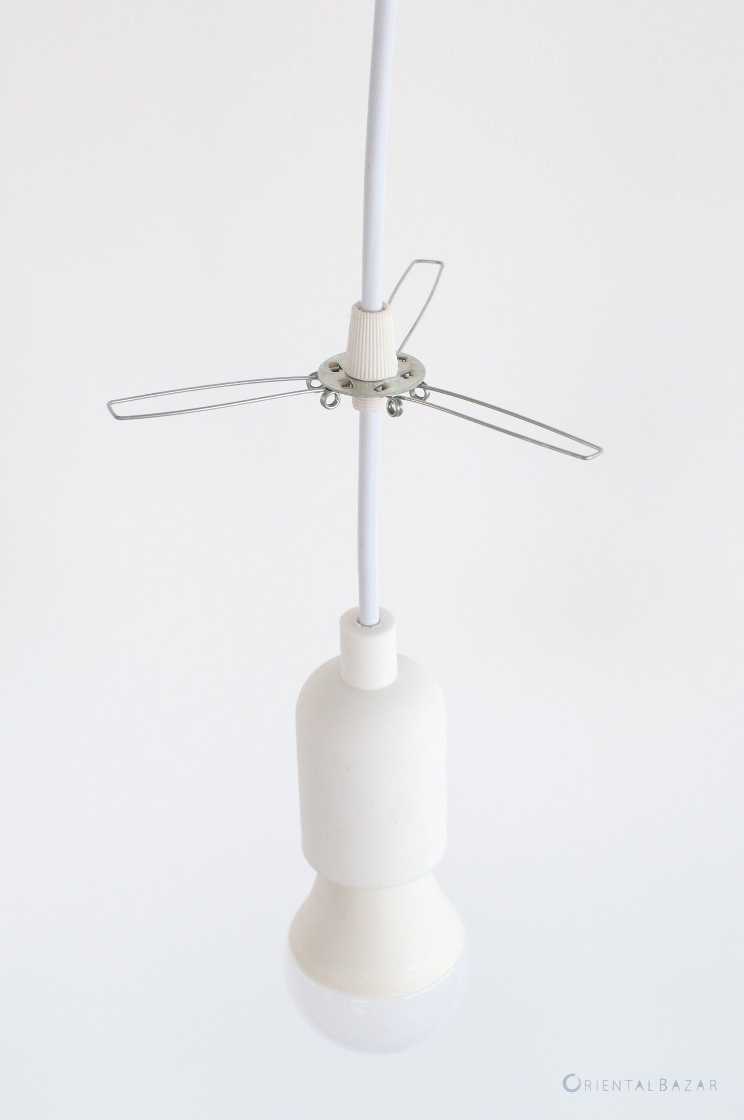 Lampshade holder fitter metal bracket attached to a white pendant light cord with white plastic grips