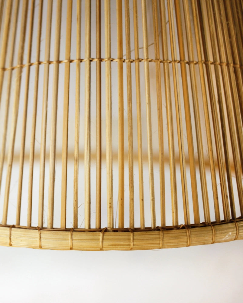 Close-up of a handwoven bamboo lampshade on a white background