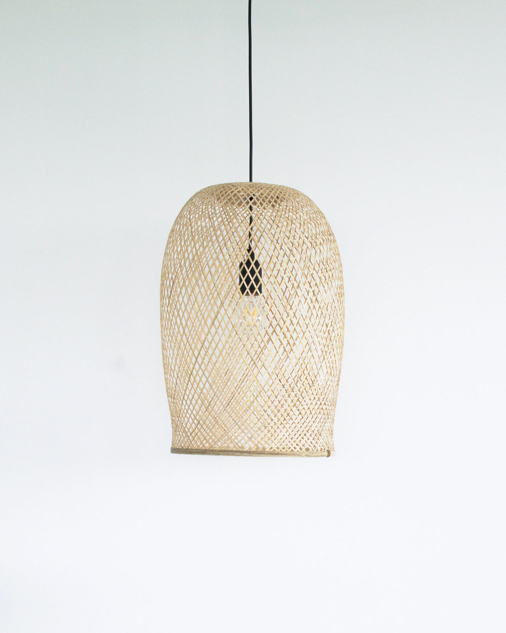 Woven bamboo pendant light on a white background