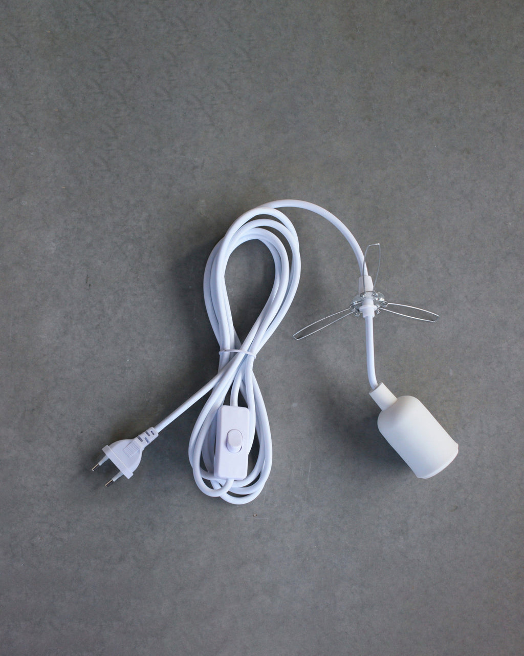 White lamp cord with plug on a gray background