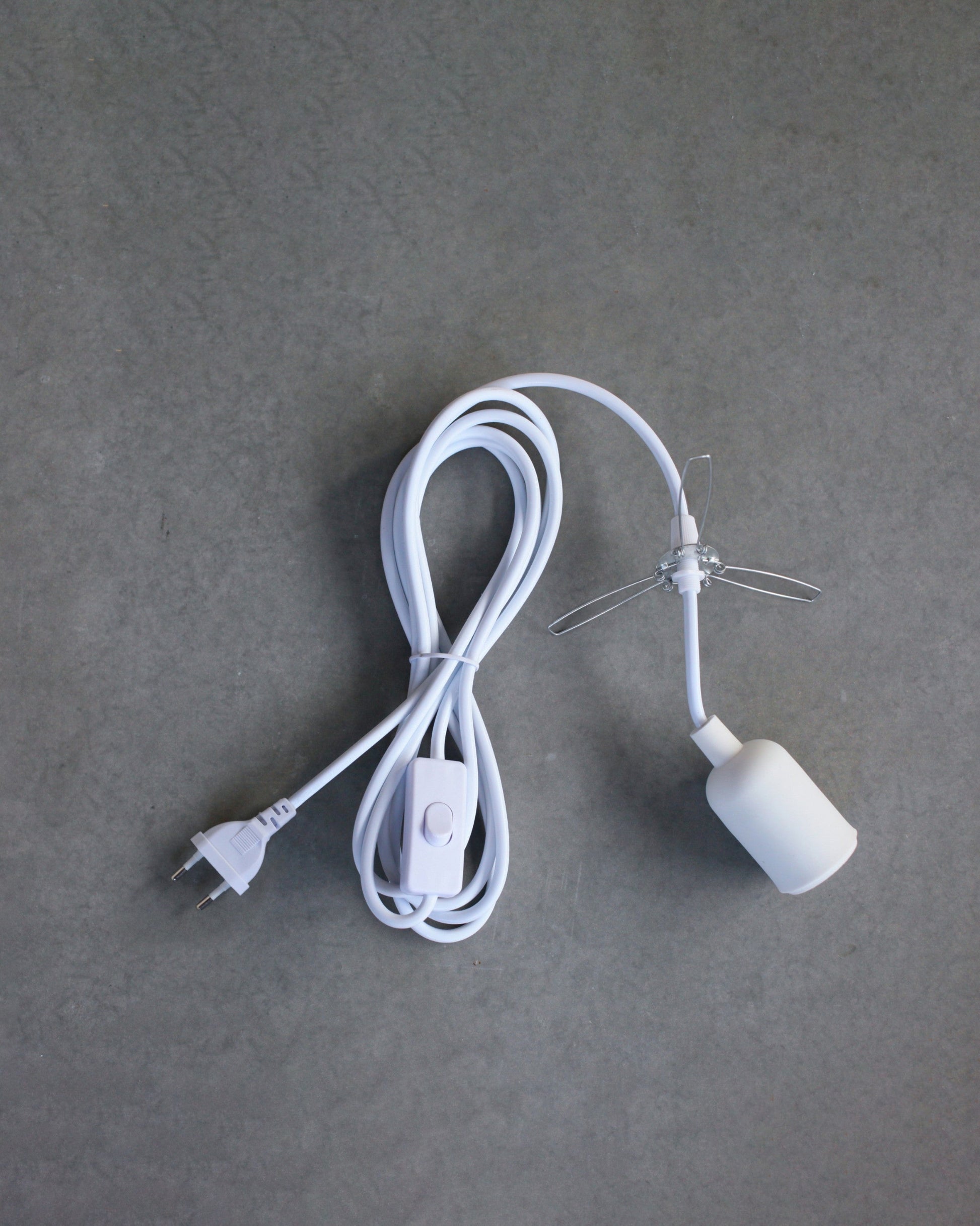 White lamp cord with plug on a gray background