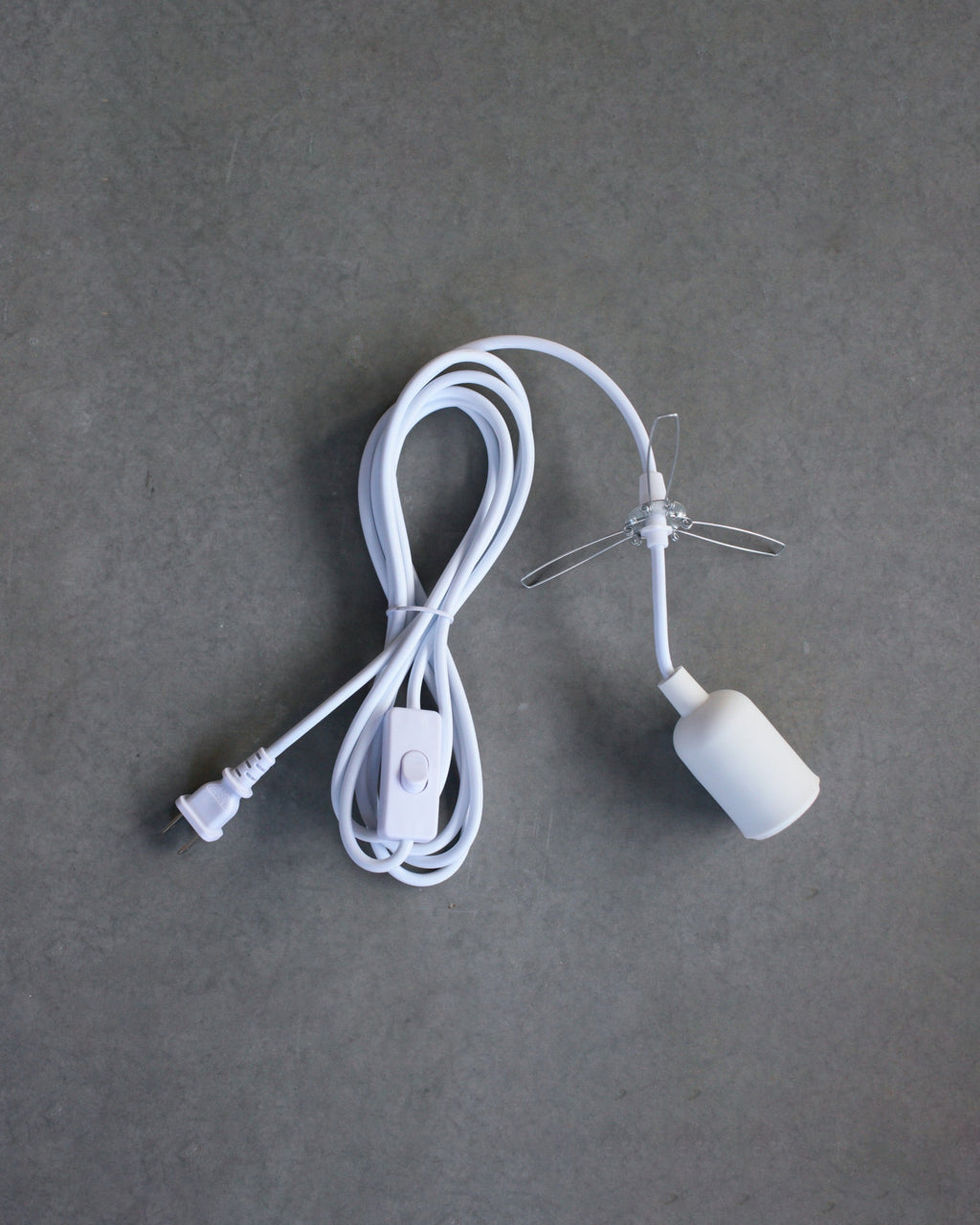 White lamp cord with plug on a gray background