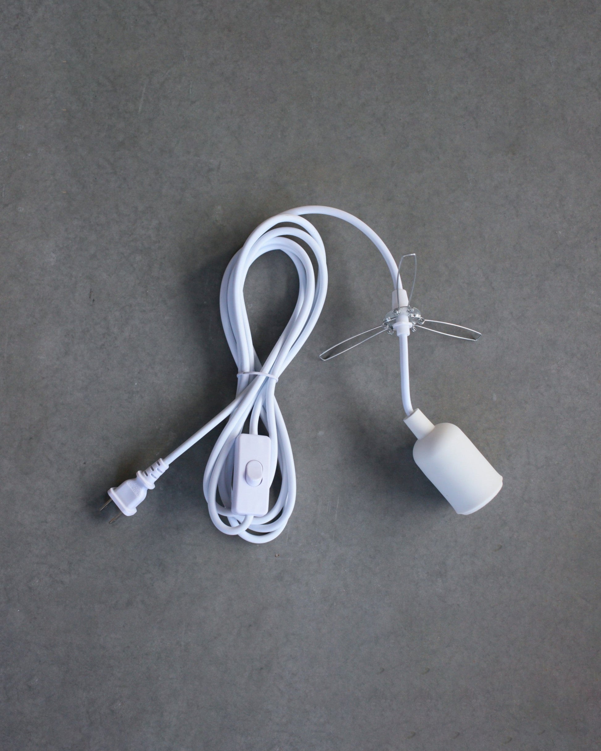 White lamp cord with plug on a gray background