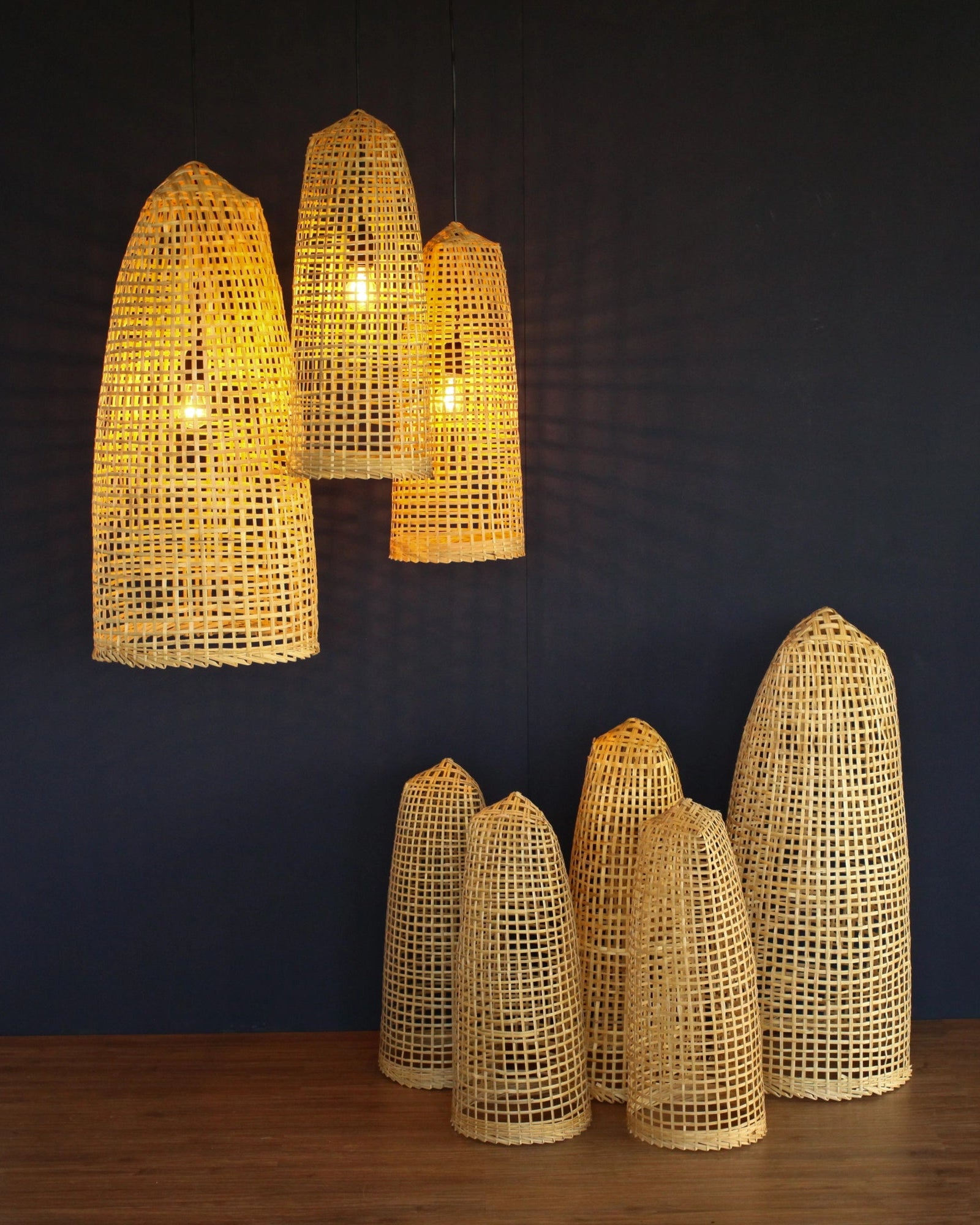 Set of woven bamboo lamps on a dark wall background