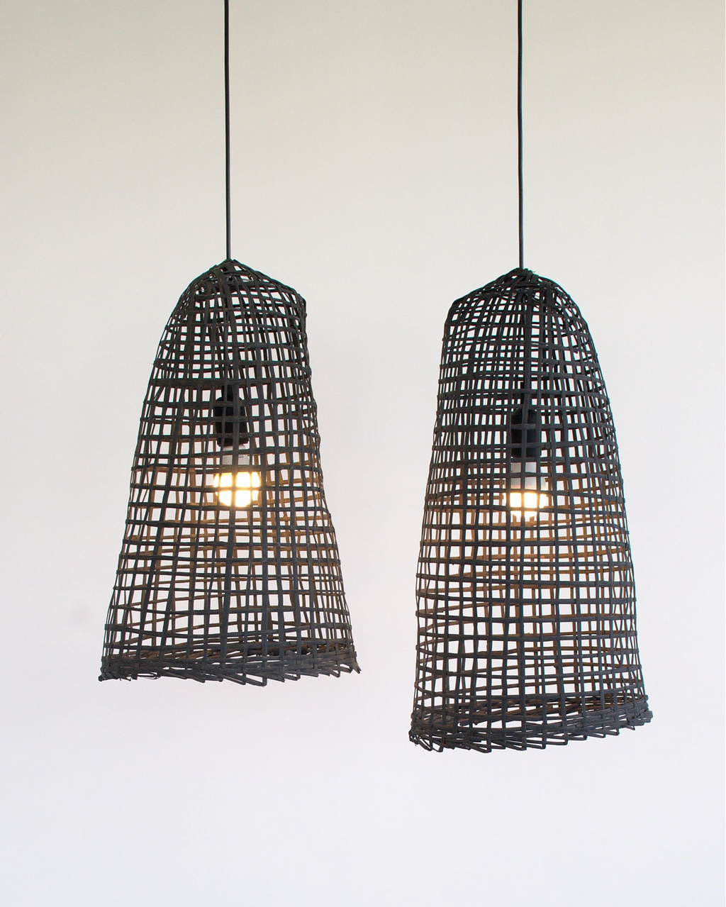 Two black wabi-sabi bamboo pendant lights on a white background