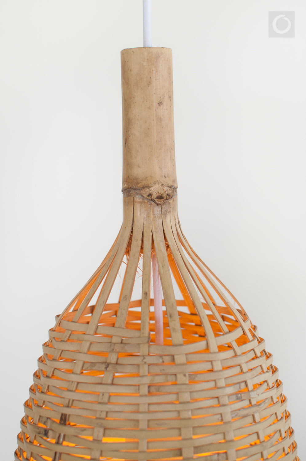 Closeup of the top of a woven bamboo pendant light on a white background