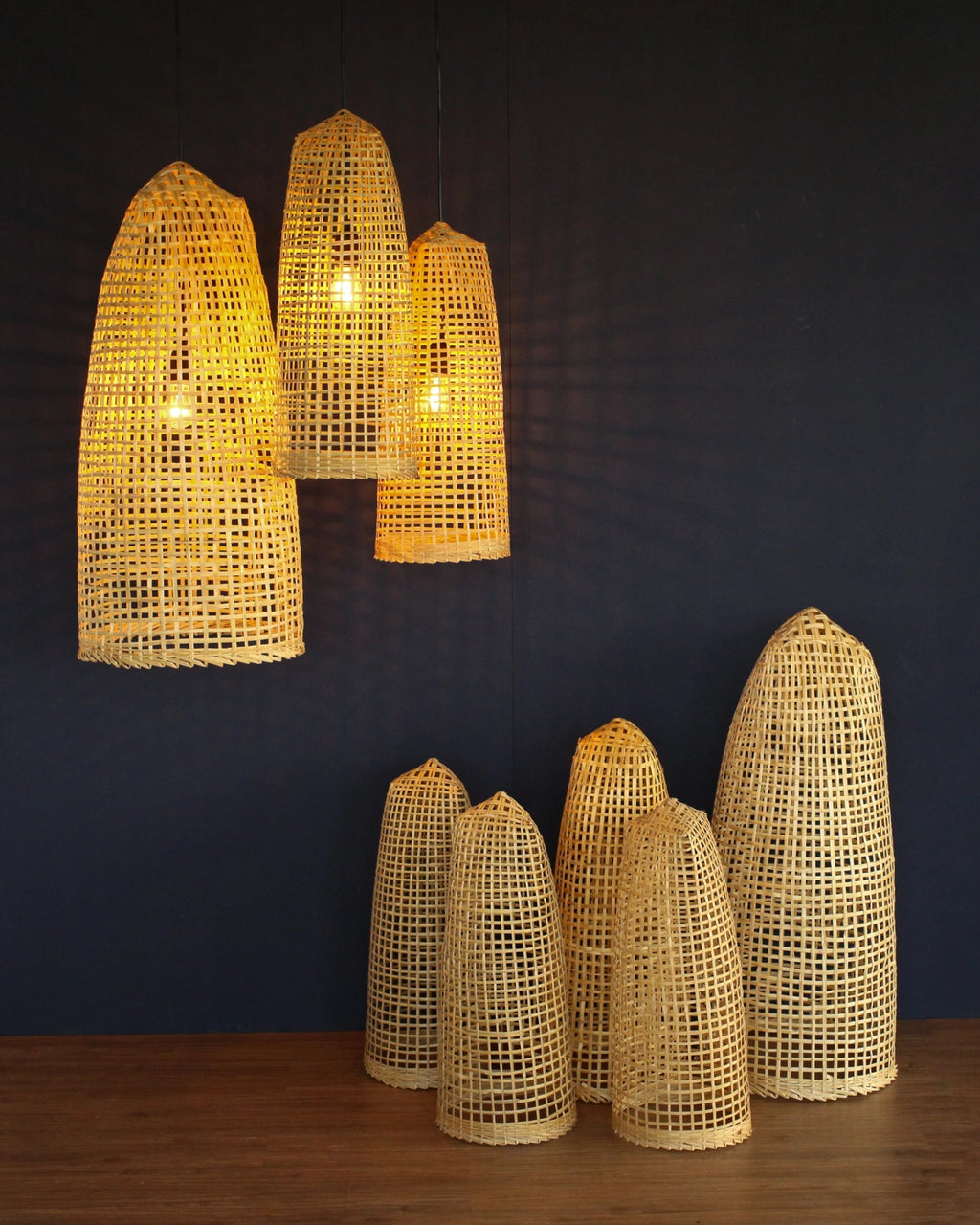 Set of woven bamboo lamps on a dark wall background