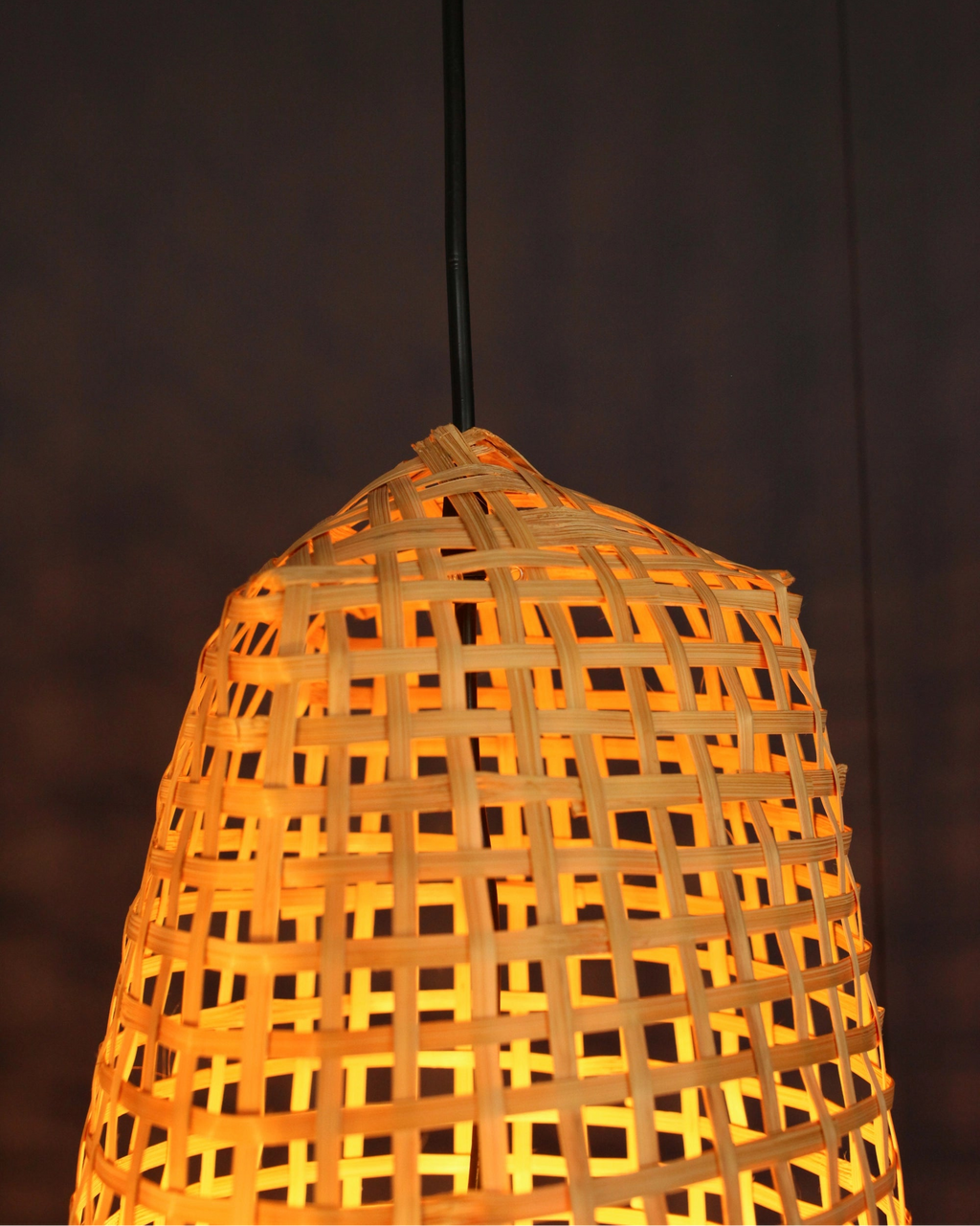 Closeup of a handwoven bamboo lampshade with a dark background