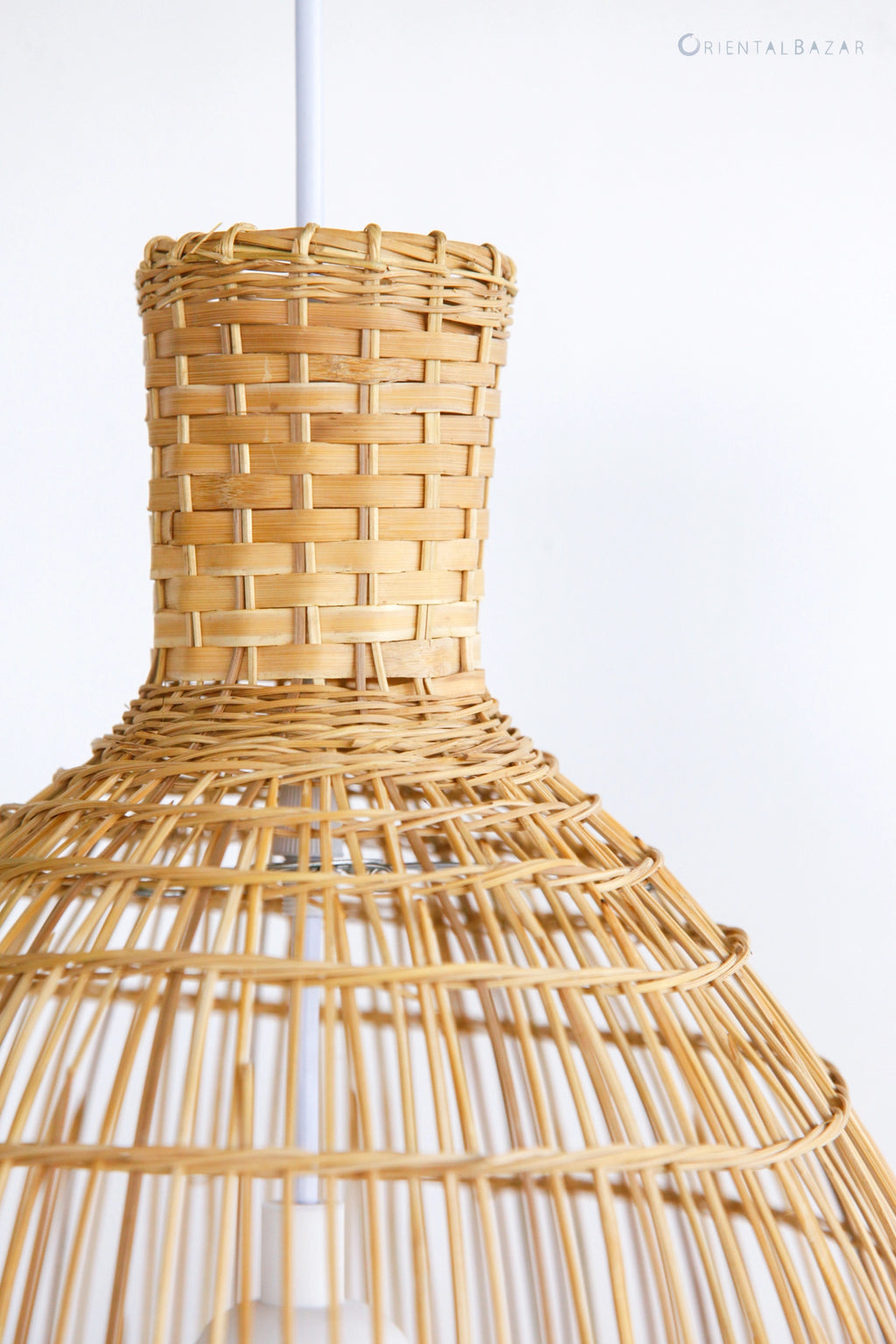 Close-up of woven bamboo pendant light against a white background