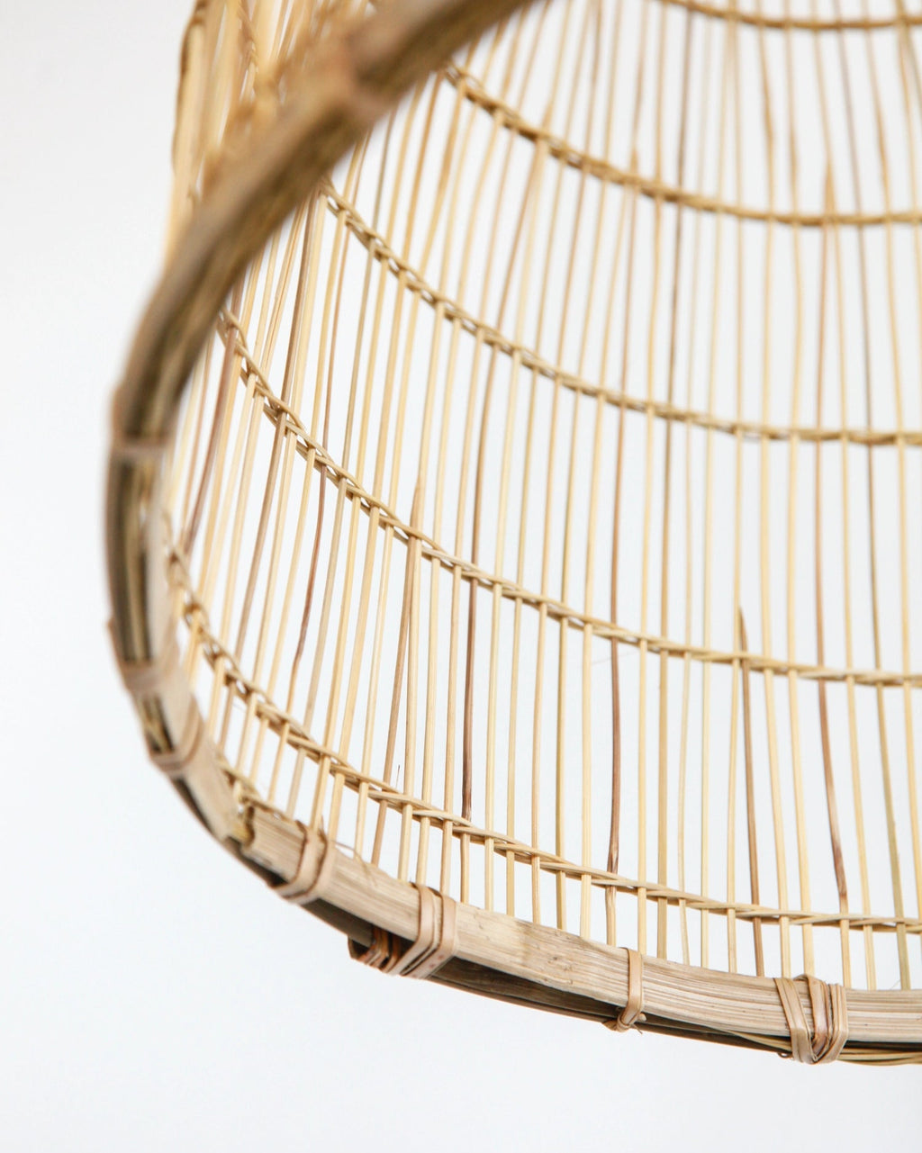 Close-up of the bottom of a woven bamboo lamp on a white background
